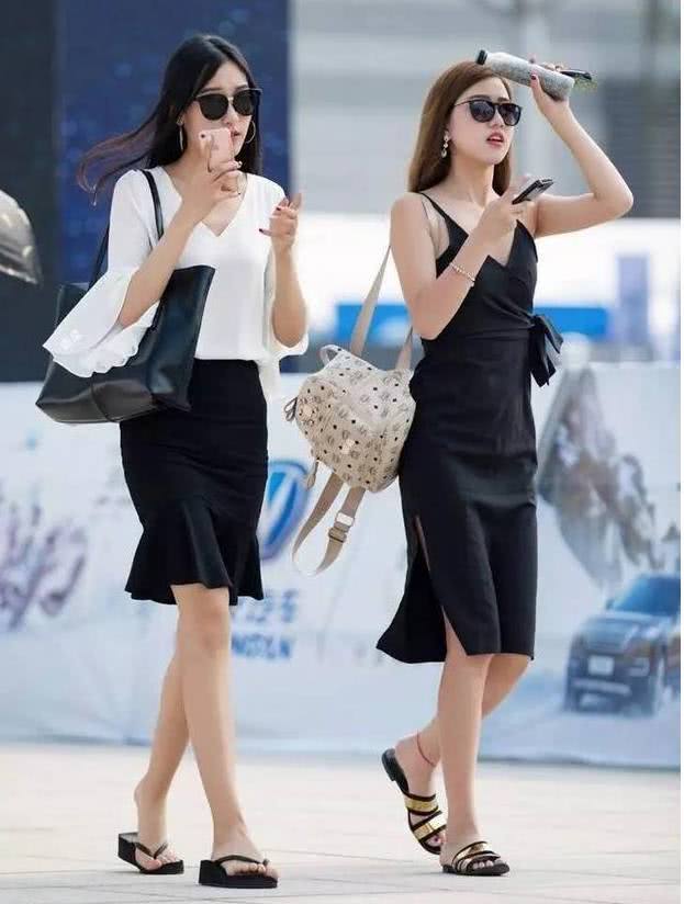 路人街拍，小姐姐一身黑色的连衣裙，白皙的皮肤格外的妩媚动人