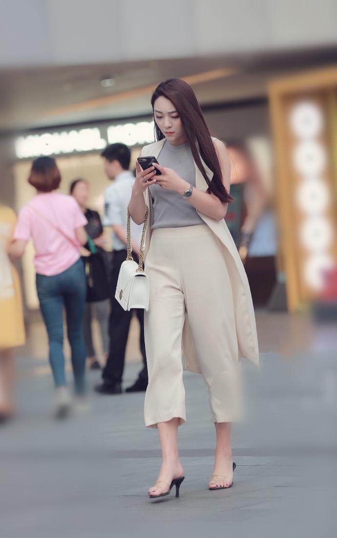 街拍：气质小姐姐紧身牛仔裤搭粉色吊带上衣凸显好身材，打扮迷人