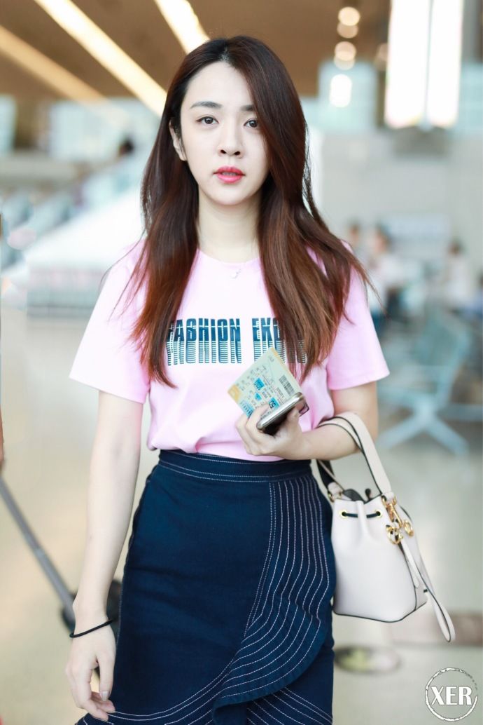 王晓晨穿粉色T恤搭配黑色荷叶边半身裙现身机场，少女感十足