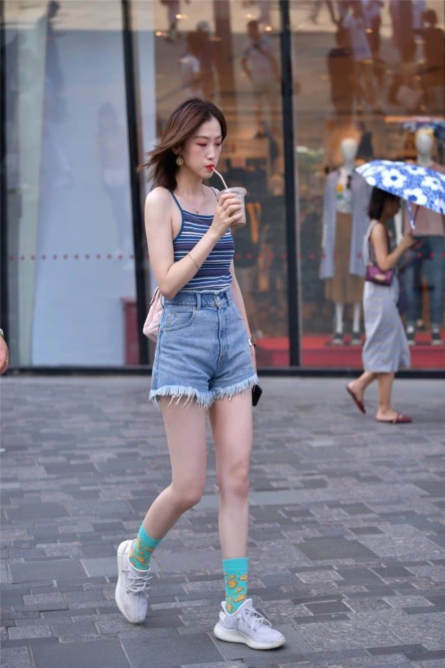  美女|街拍：边走边喝饮料的美女，清爽的背心搭配牛仔热裤，显得非常潇洒帅气