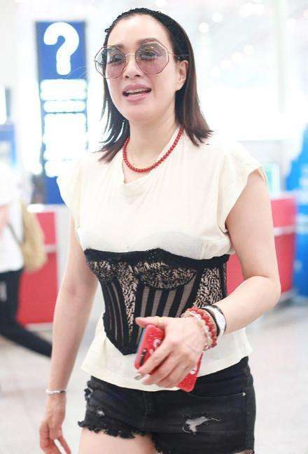 钟丽缇现身机场，T恤搭腰封秒变小腰精，不料却被赘肉抢去了镜头