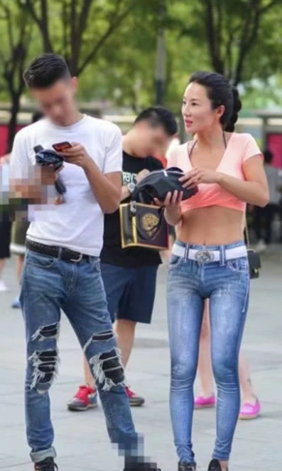 风韵小姐姐穿着牛仔紧身裤尽显玲珑曲线，白色腰带搭配的很亮眼