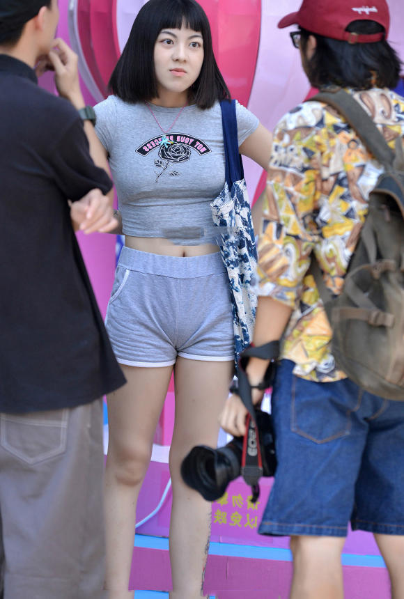 气质萌妹短裤秀出一双白皙透彻的美腿，摇摆的姿态很是俏皮