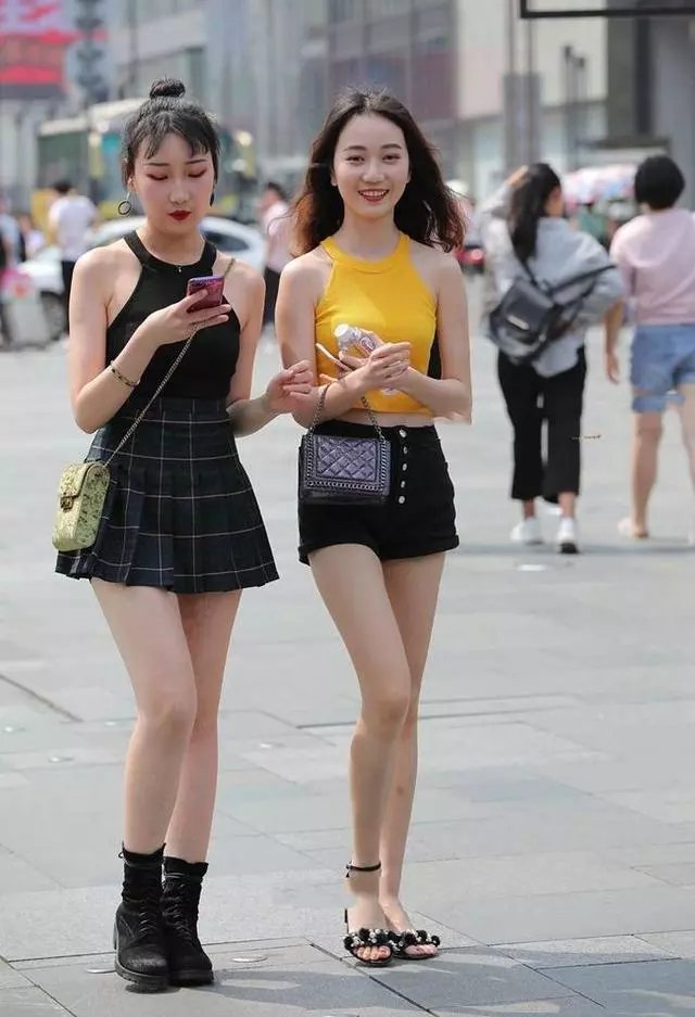 路人街拍，紧身连衣裙展现了女性的优雅，两个小姐姐看上去很性感