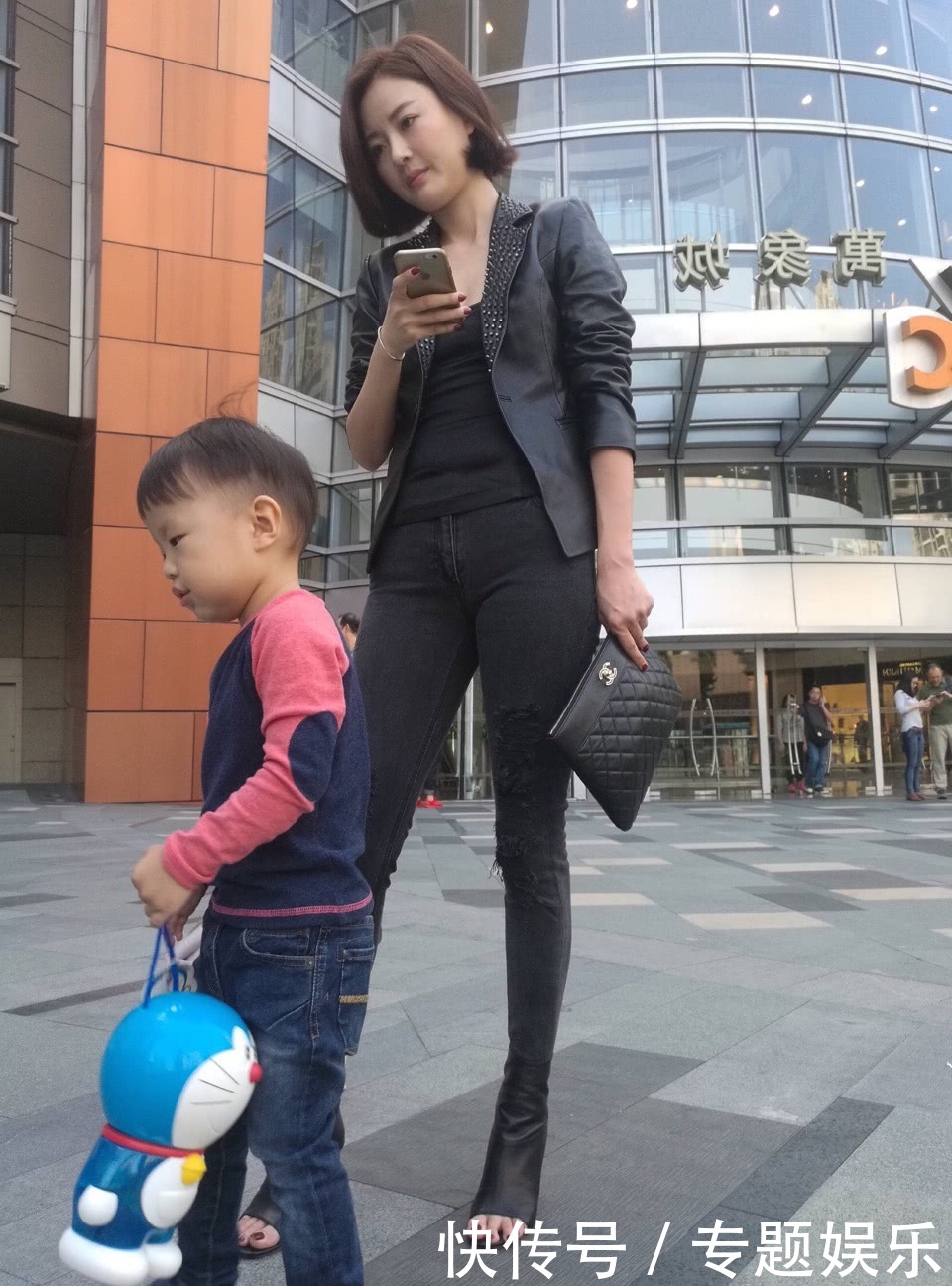 辣妈皮衣搭配牛仔裤曲线凹凸有致，穿高跟鞋带娃很随意，霸气十足