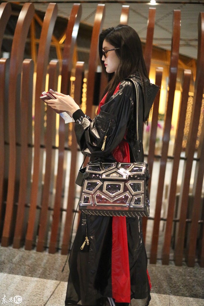 超模何穗现身北京机场，一身雨衣，难掩美腿