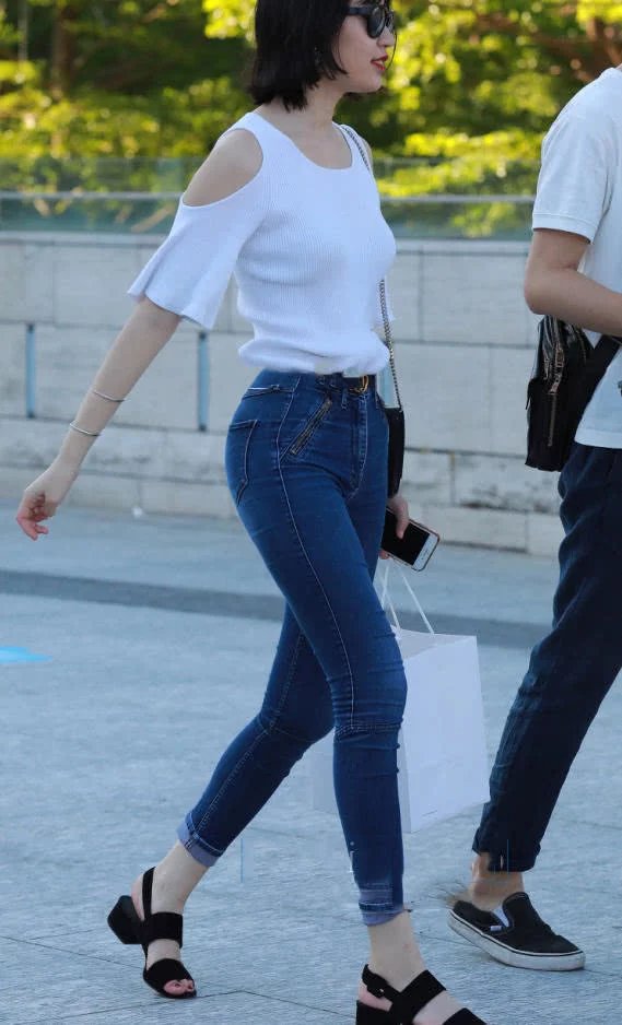 时尚小姐姐紧身牛仔裤勒出大长腿，身材凸凹有致