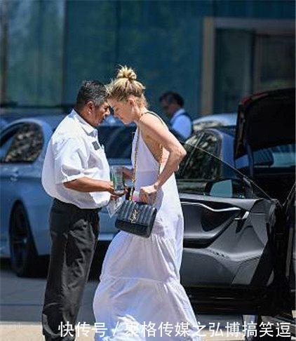 艾梅柏·希尔德穿纯白长裙大散文艺气息，街头匆忙赶行程露美背