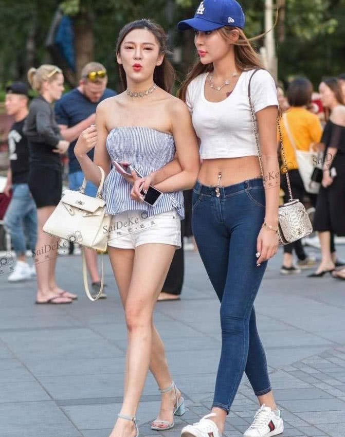 紧身裤小姐姐双腿修长，旁边的闺蜜则是一个超短裤，腼腆的笑容很