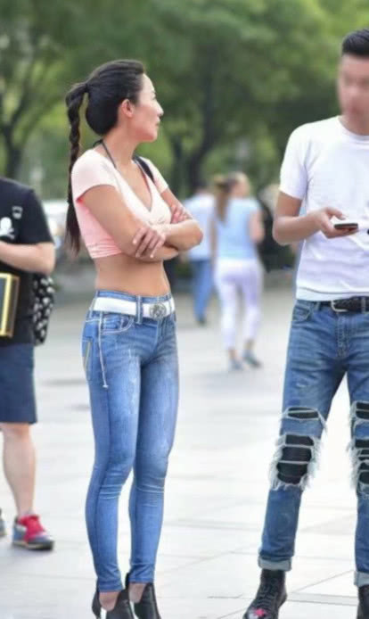 风韵小姐姐穿着牛仔紧身裤尽显玲珑曲线，白色腰带搭配的很亮眼