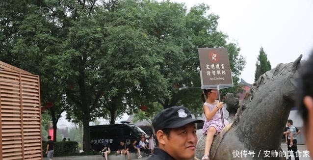 游客攀爬景区雕塑拍照,保安喊话劝告无效,沉默地递上一牌子