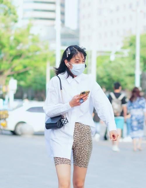  衬衫下摆的左侧塞进@街拍：豹纹骑行裤搭配白衬衫，美女懂时尚会穿搭，优雅性感就属她