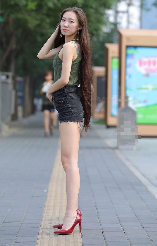 路人街拍，小姐姐上身穿的是露背紧身的吊带装，很有气质