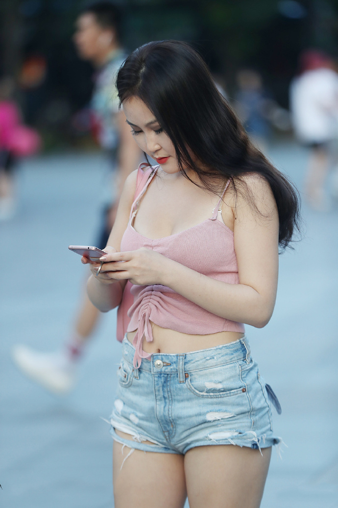 小姐姐身穿粉色吊带衣，手中的东西太重，弯腰放东西的姿态真美！