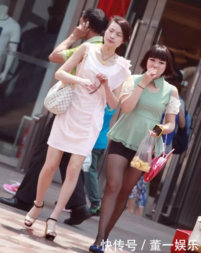 妙龄少妇微胖身材搭配黑丝很有看点，行走街头当众吃榴莲，一旁闺