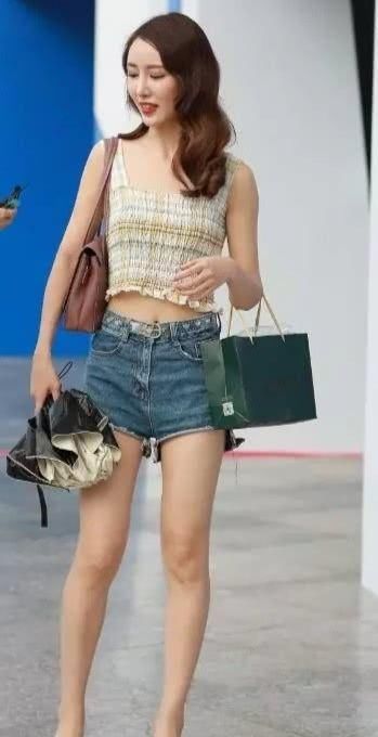  感觉：街拍：小姐姐深蓝色的牛仔色系热裤让人感觉非常的时尚抢眼