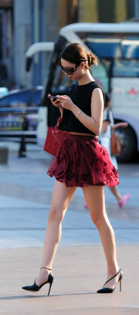 成熟小姐姐穿红色褶皱裙秀出纤长白皙美腿，长腿搭上细高跟很迷人