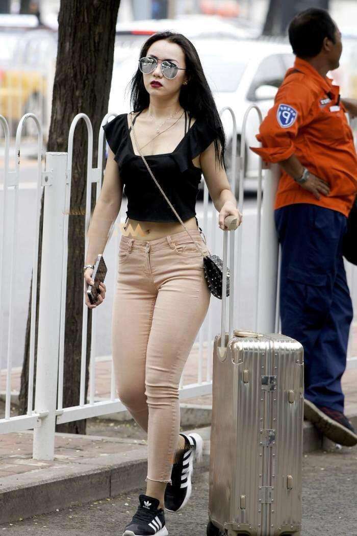 街拍：吊带小姐姐穿紧身牛仔裤出门，身材微翘