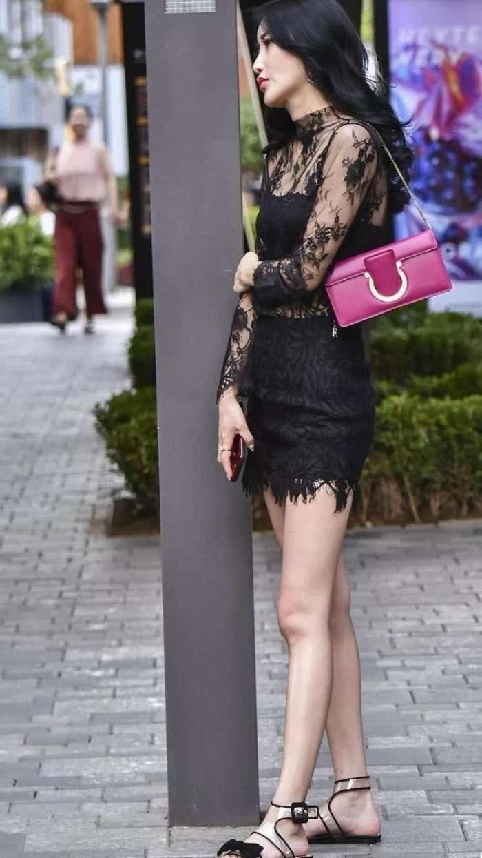 穿黑色蕾丝的美女走在大街，展现出与众不同的时尚风格