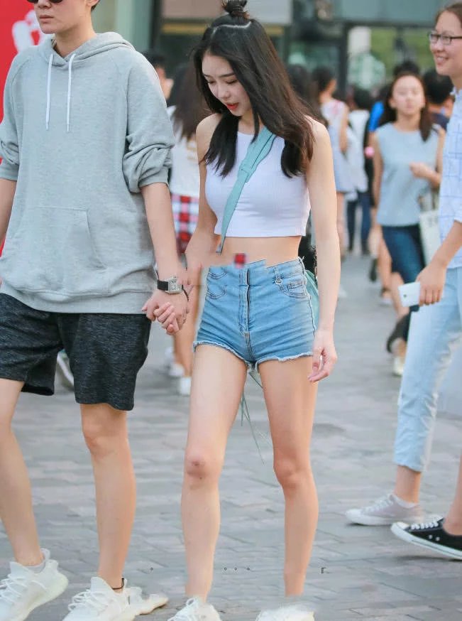 性感小姐姐吊带漏脐装搭配超短牛仔裤，丰润的双腿很吸睛，值得一