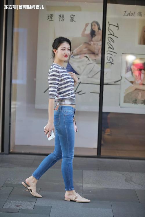 路人街拍：时尚小姐姐紧身牛仔裤勾勒修长美腿，彰显女神气质！