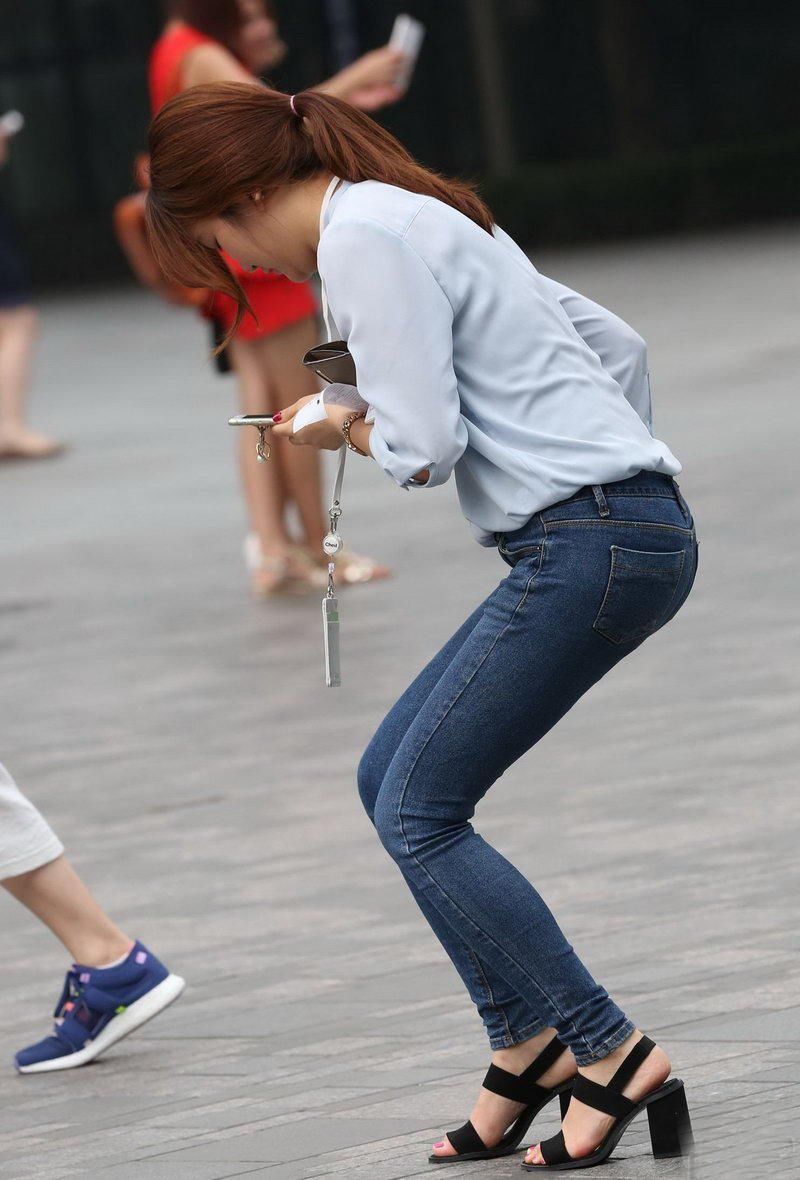 万泉广场街拍:紧身牛仔裤美眉，尽显迷人曲线