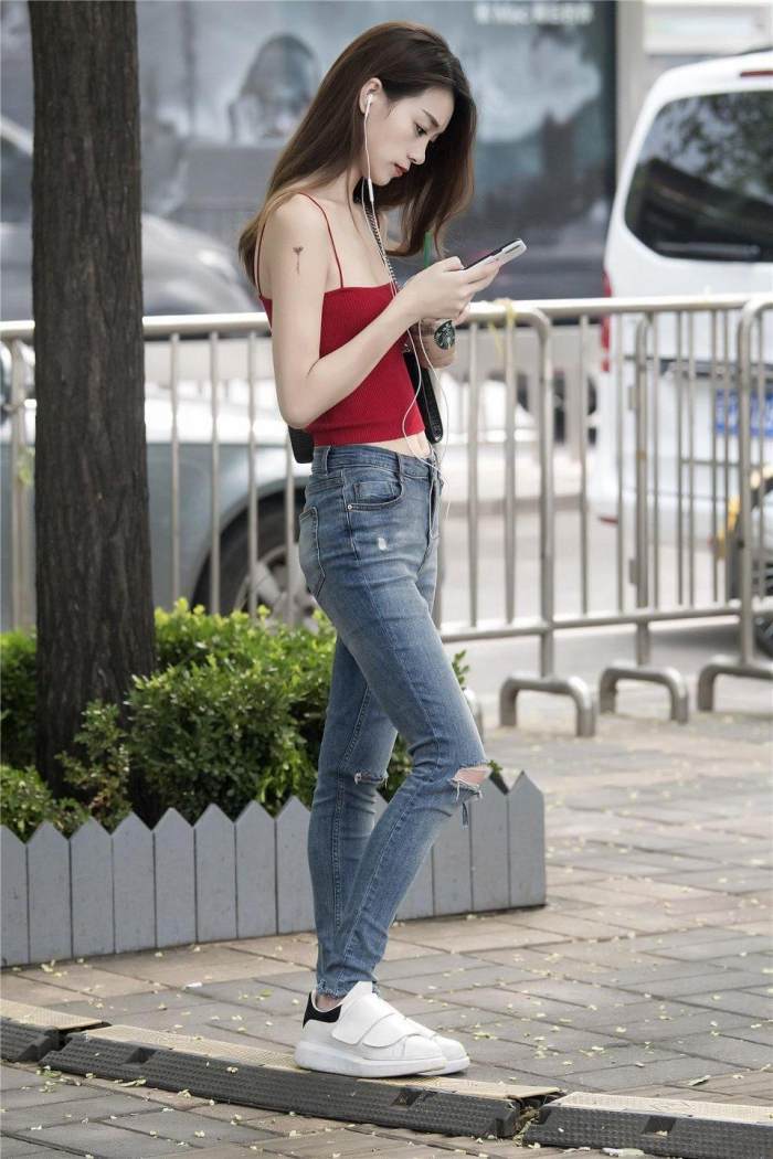 小姐姐选择了一款红色的吊带, 白皙动人的肌肤很是靓丽