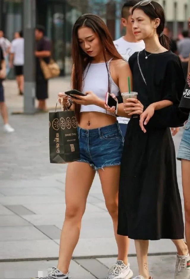 辣妹热裤秀笔直双腿和健美蛮腰，真空穿着背心，时尚又俏皮