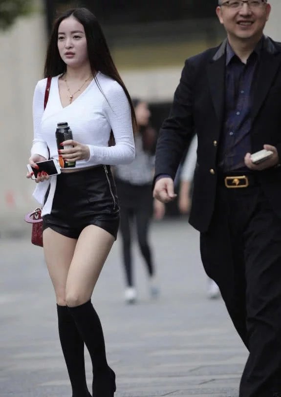 气质小姐姐黑色小皮裤包裹着肥硕性感的臀部，丰腴事业线走上街吸