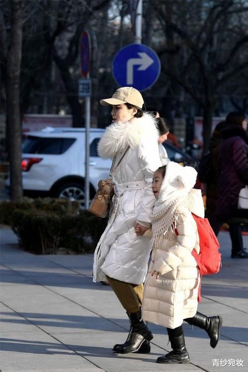  美女：美女穿长款羽绒服，修身裤搭配毛绒绒的棉鞋，显出纤瘦身材
