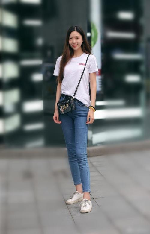 路人街拍，许多小姐姐都喜欢穿修身的牛仔裤，走起路来十分动人