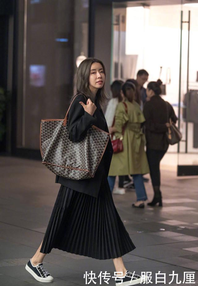 『蓝色』街拍:美女长发随风飘动,蓝色的毛衣搭配黑色的半身裙,气质出众