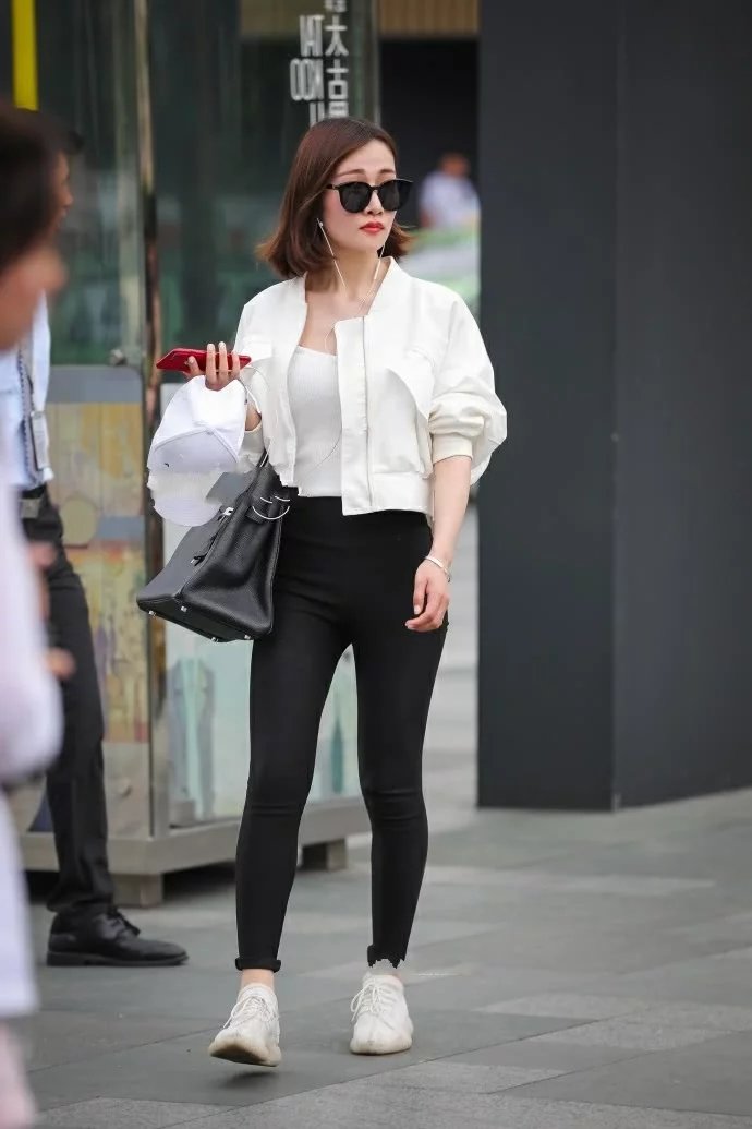 气质小姐姐黑色紧身裤绷出时尚美腿，一边走一边嘟嘴撩发萌态十足