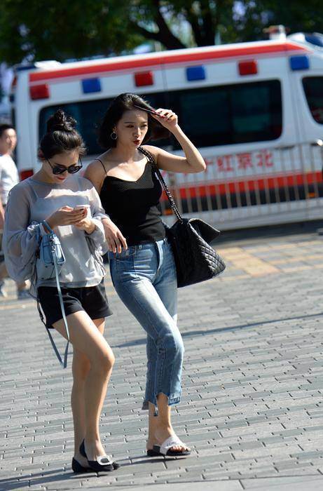 路人街拍，小姐姐一身短裙在阳光下闪闪发光，发色靓丽惹人注目