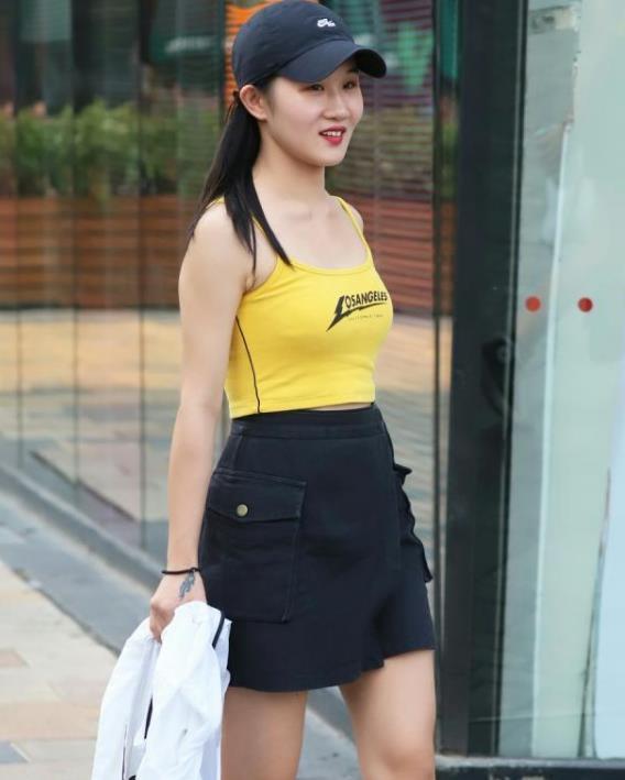  身穿|街拍：面带微笑的小美女，身穿吊带背心配黑色短裙，青春活力气息