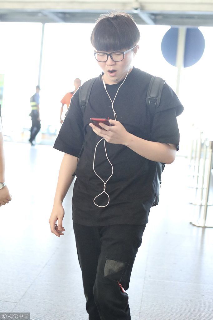 毛不易全黑look扮酷机场边走边听歌 “苹果脸”配“西瓜头”自带