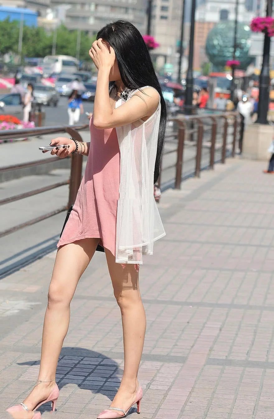 优雅的小姐姐粉红吊带裙勾勒丰满上围，拿手遮阳的样子很有小女人