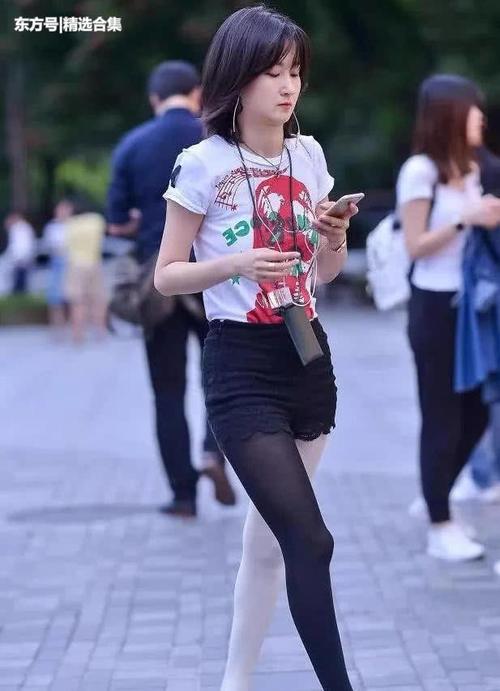 街拍：气质小姐姐高挑热裤显苗条修长双腿，黑白丝袜非常有个性
