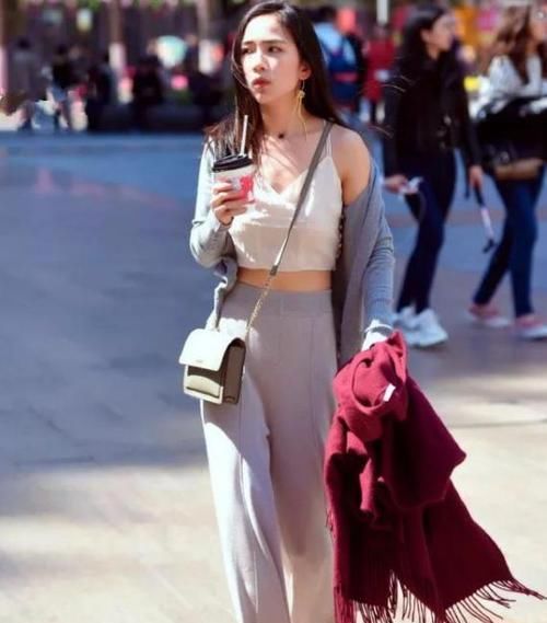 「紧身裤」街拍:身材苗条的美女,一件墨绿色上衣配黑色紧身裤,时尚气质