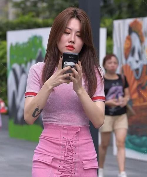  『粉色』养眼女神街拍：软玉温香的美女，一件白色背心配粉色裤子，时尚清爽迷人