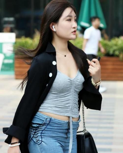 「美女」街拍:皮肤白皙的美女,一件黑色开衫配蓝色牛仔裤,时尚气质十足
