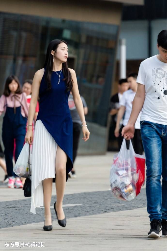 美女穿对半“跳色”连衣长裙，行走间总会有白皙美腿的出现!