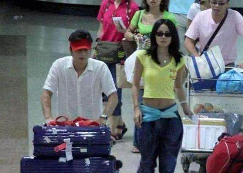 48岁王菲现身机场, 露脐装一片哗然, 网友: 丝巾当腰带够大胆!