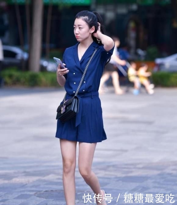 面带微笑:街拍:面带微笑的小姐姐,一条蓝色连衣裙外搭黑色外套,十分迷人