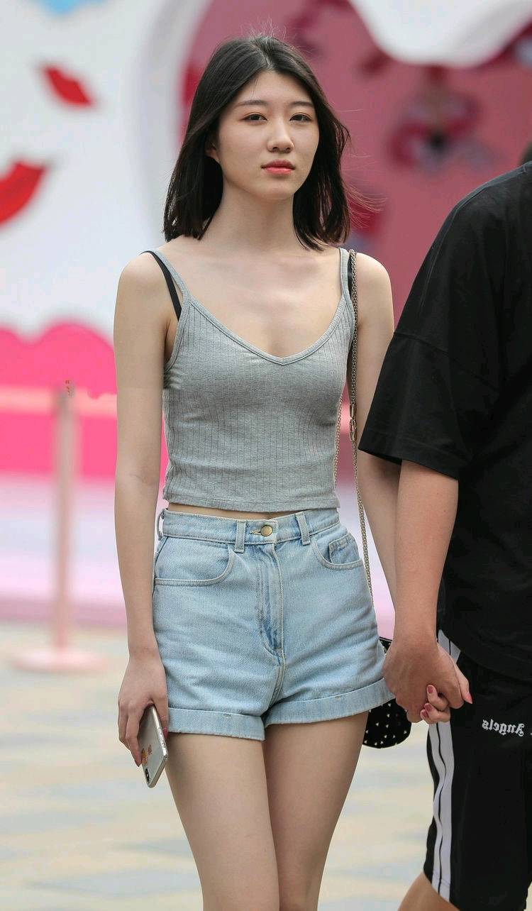 街拍，美女身穿黑色运动型内衣，搭配黑色牛仔热裤，身材丰满！