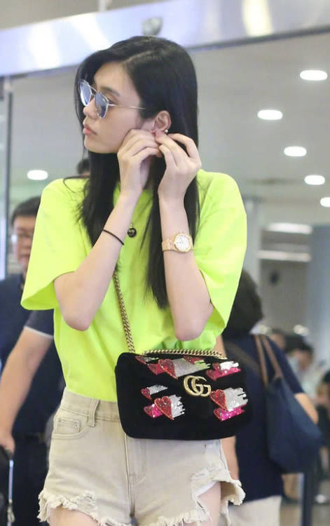 奚梦瑶穿荧光绿现身机场，超短裤大秀美腿，却被耳朵尴尬抢镜！