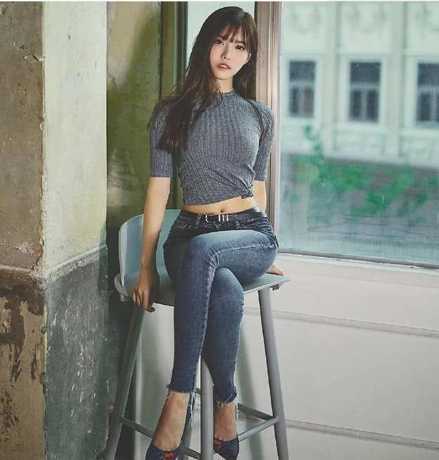 紧身牛仔裤剪裁利落，将妹子腰部的线条修饰的更加纤细优美！