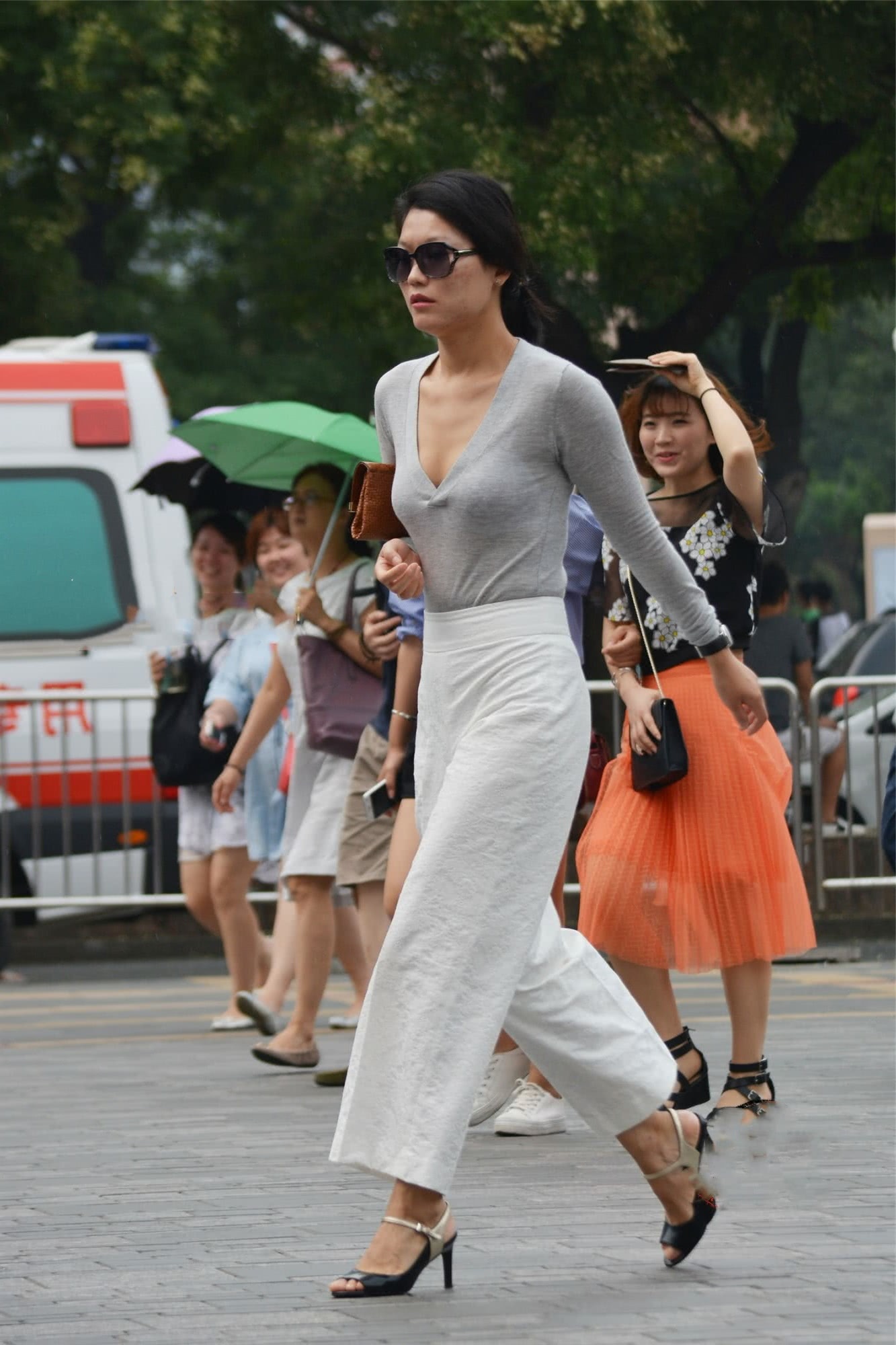 气质小阿姨紧身T恤裹出丰腴线条，手拿包包的姿态展现霸道女神范