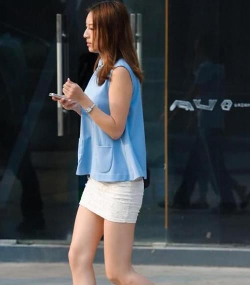 「紧身裤」街拍:身材苗条的美女,一件墨绿色上衣配黑色紧身裤,时尚气质