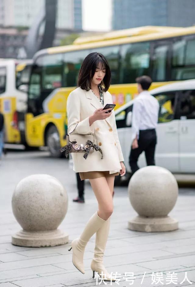  「美女」美女短裙搭配一双米白色的高跟靴子，让整体的感觉十分的协调